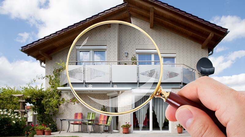 Person Hand With Magnifying Glass Over Luxury House
