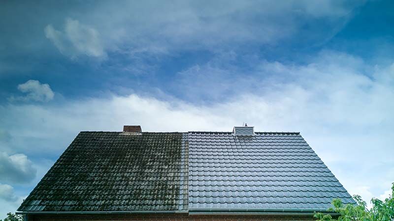 Before and after comparison of a roof during professional moss and algae cleaning in Atlanta.
