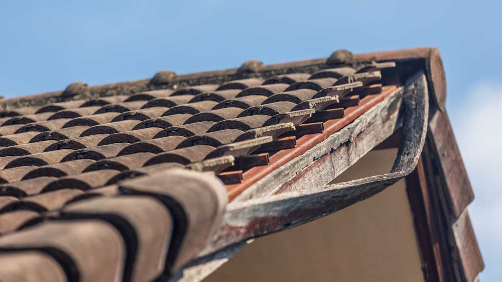 Roof tile damage and structural damage to a home's roof in Atlanta after storm.