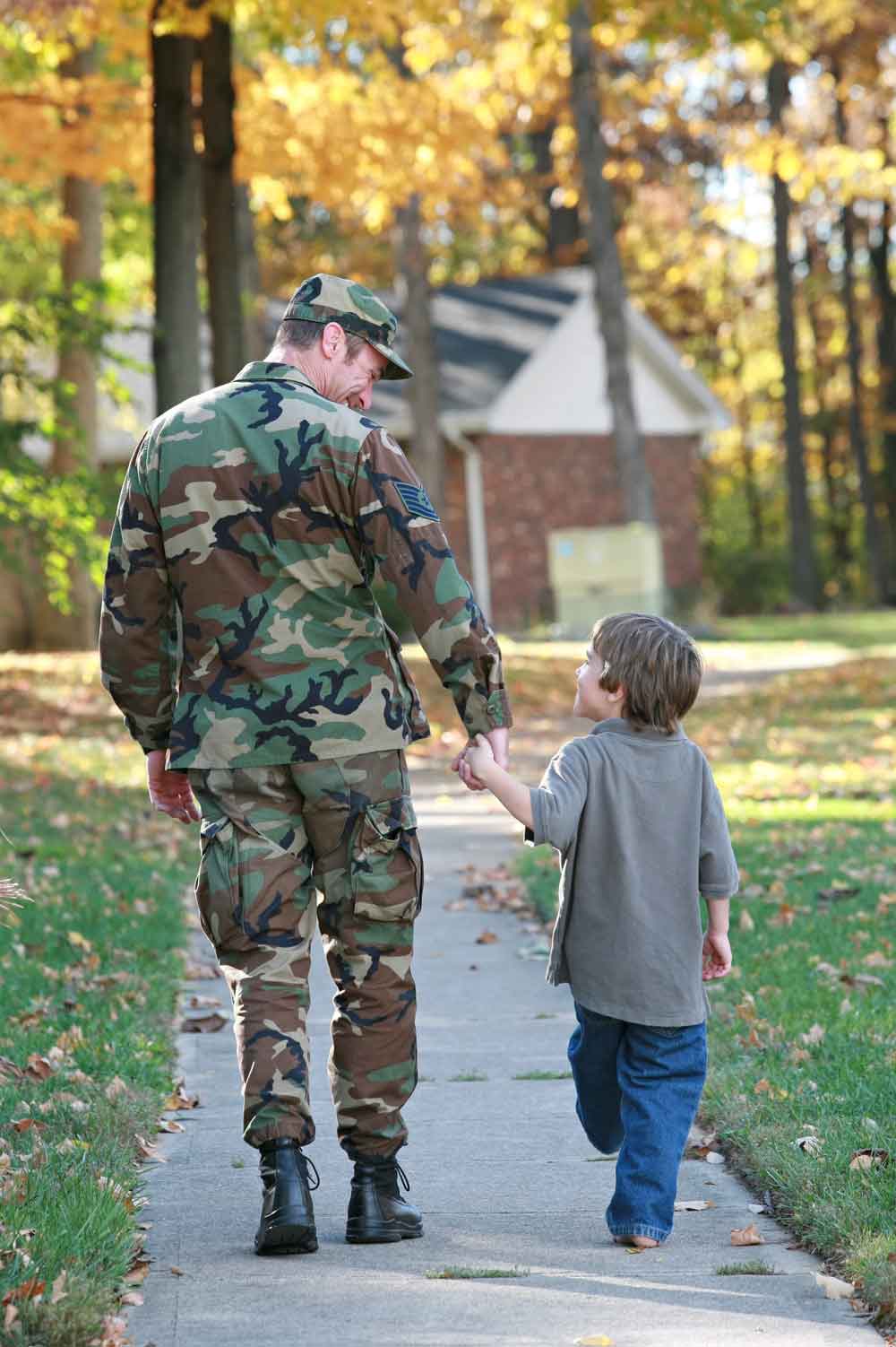 US Army serviceman walking with his young son. 