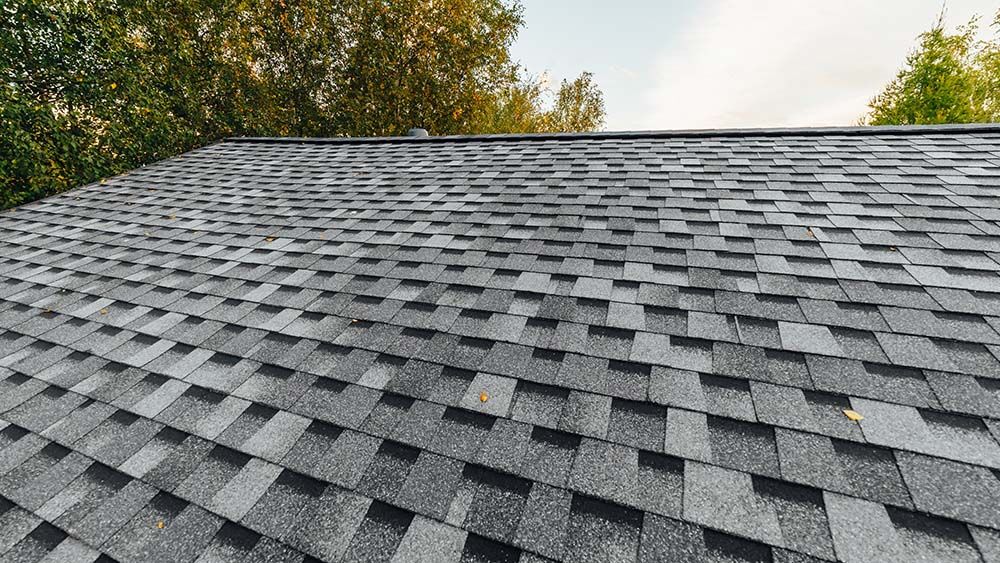 new renovated roof covered with asphalt shingles