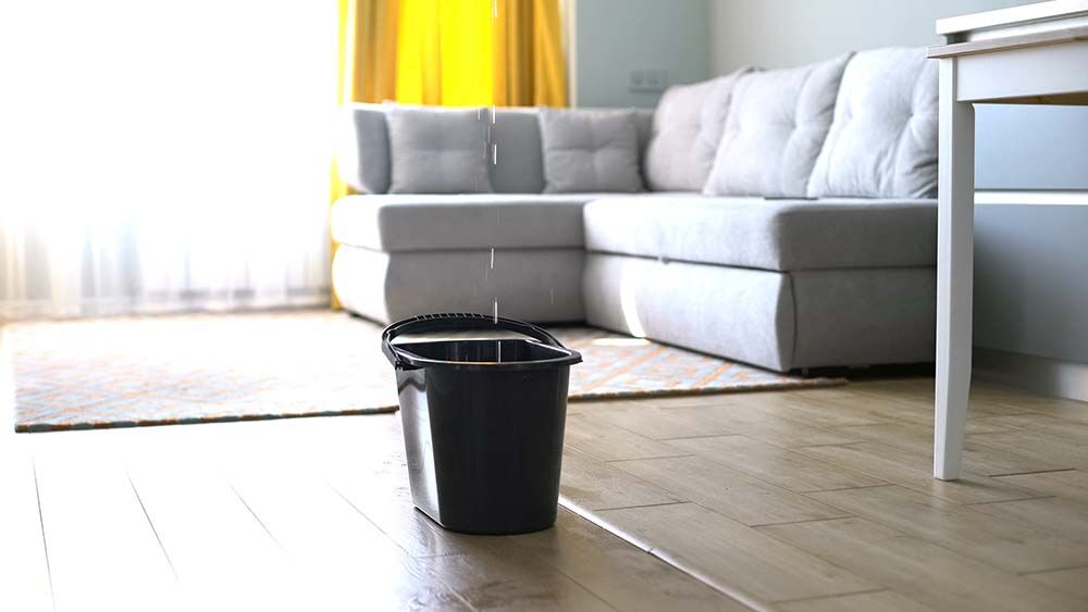 Water droplets leaking in bucket from ceiling,