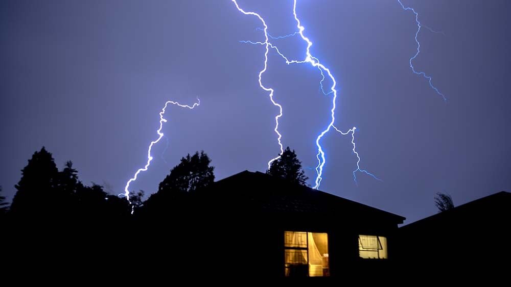 Cloud,To,Ground,Urban,Lightning,,Lighting,Up,House,Rooftops,Silhouetting lightning strike over house