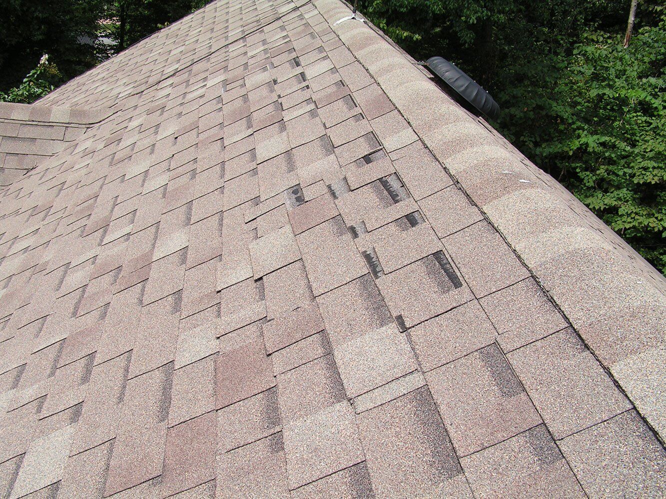 Roof repair needed for loose shingles and granules. 